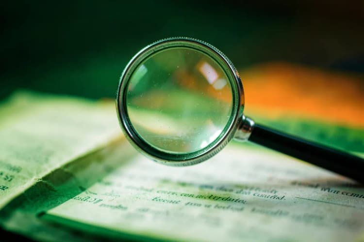 Lupa examinando um documento de orçamento de impressão em busca de detalhes.