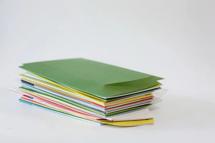 Um conjunto de pastas de arquivo e blocos de notas empilhados, sugerindo organização para um evento.