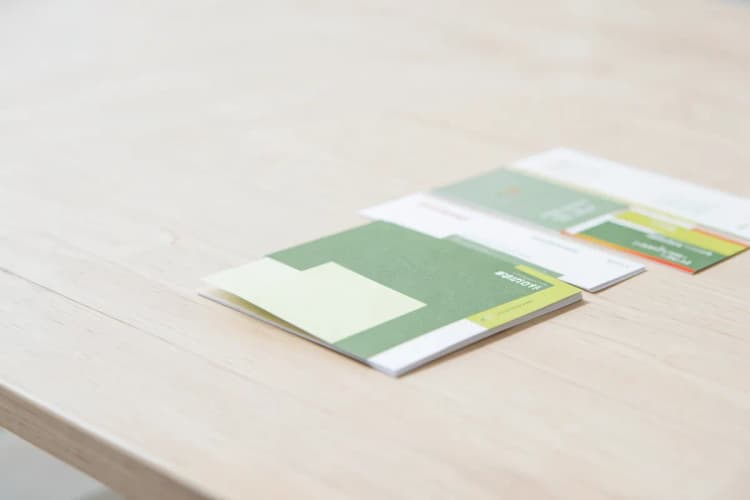 Impressão de materiais gráficos como cartões de visita e folhetos em uma mesa.