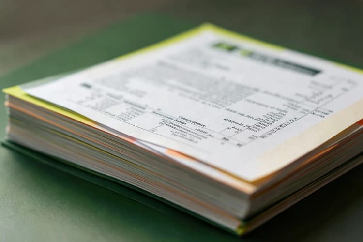 Uma pilha de papéis de impressão com um orçamento sobreposto, mostrando detalhes do texto e da formatação.
