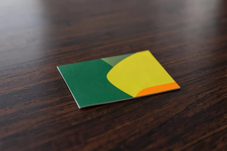 Um cartão de visita elegante sobre uma mesa de madeira escura, simulando um ambiente de negócios.