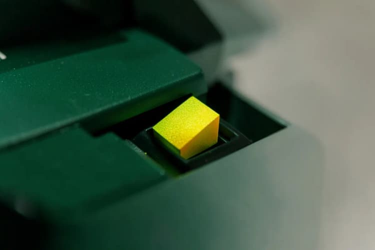 Close-up de um chip de toner sendo inserido em uma impressora digital.